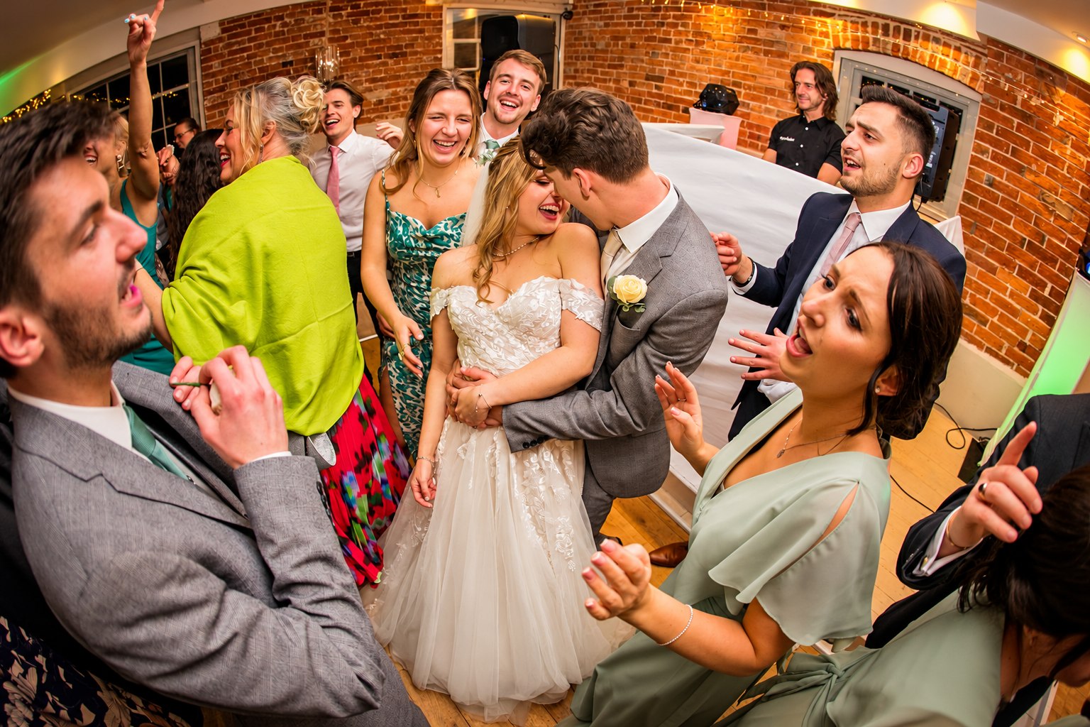 Newlyweds and guests celebrating on a lively wedding dance floor