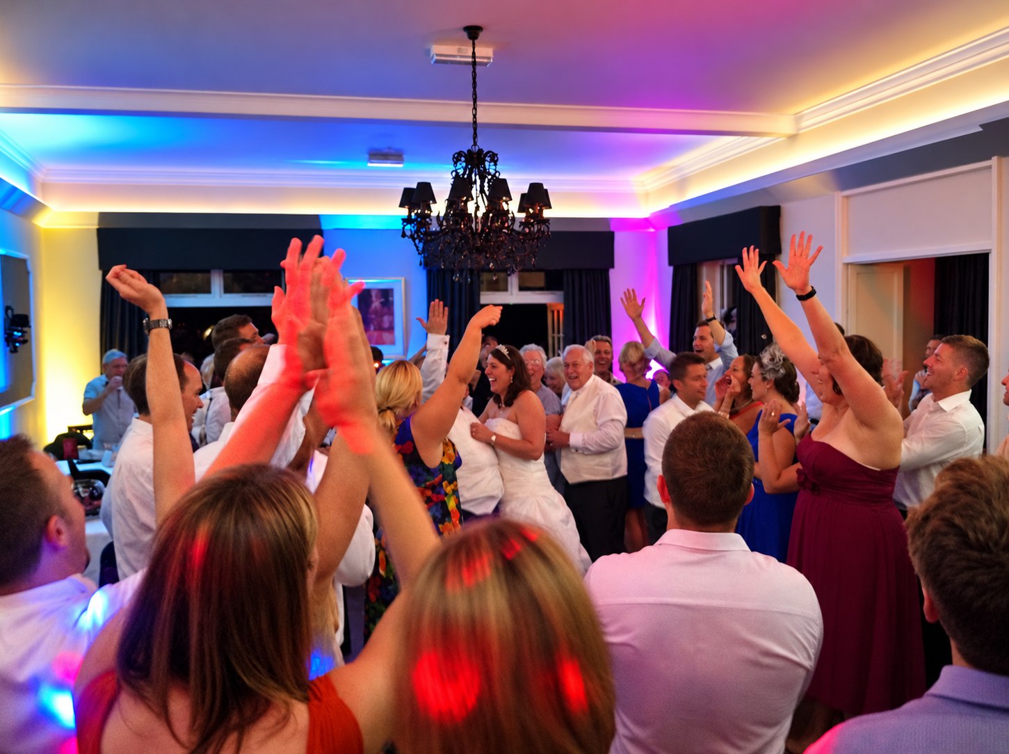 Packed wedding disco dance floor in Bournemouth with colourful lighting